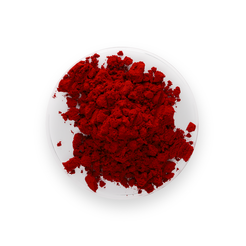 A pile of vibrant red powder of astaxathin, likely cosmetic or pigment powder, displayed on a small white plate against a solid white background.
