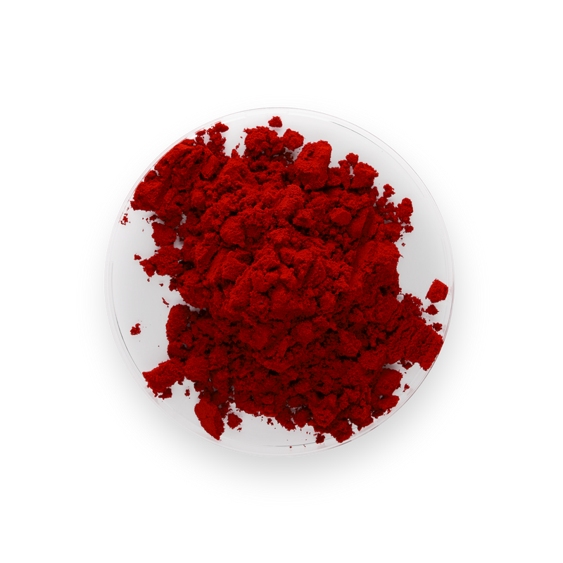 A pile of vibrant red powder of astaxathin, likely cosmetic or pigment powder, displayed on a small white plate against a solid white background.