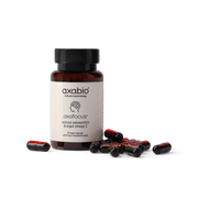 A bottle of axabio Axafocus dietary supplement capsules with several red and black capsules scattered in front, set against a solid white background.