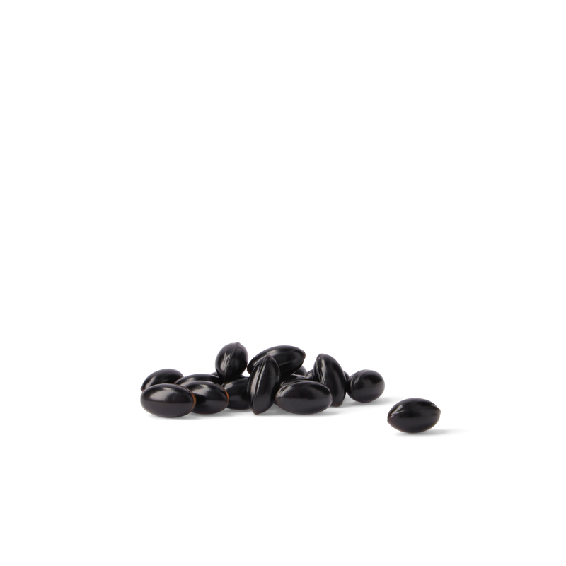 A small pile of glossy black beans with one bean placed to the right, photographed on a clean white background.