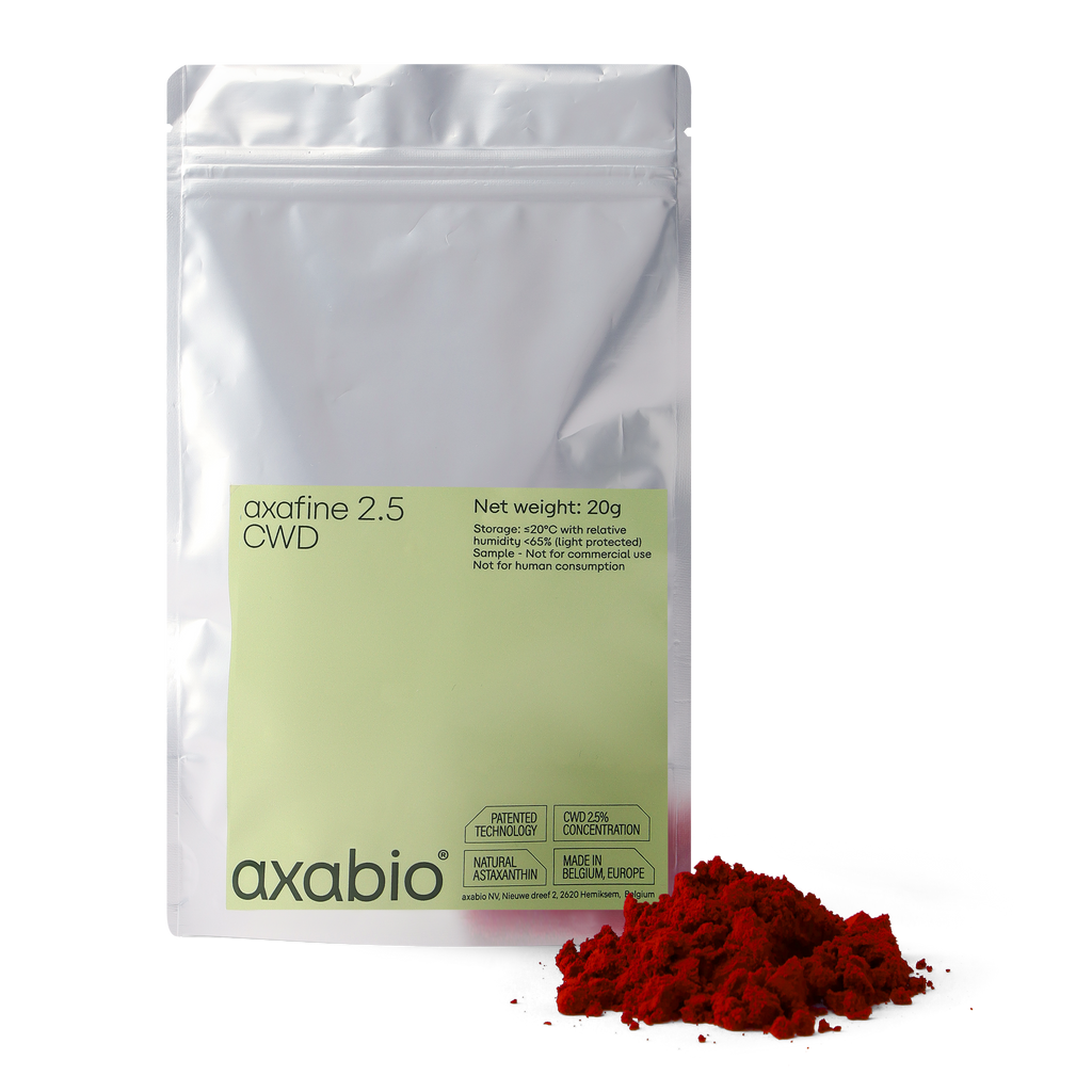 A silver stand-up pouch labeled 'axabio axafine 2.5 OWD' with a pale green label, shown on a white background with a small pile of bright red astaxanthin powder in front.
