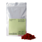 A silver stand-up pouch labeled 'axabio axafine 2.5 OWD' with a pale green label, shown on a white background with a small pile of bright red astaxanthin powder in front.